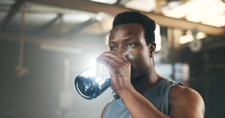 Téléchargez les photos : Homme noir au gymnase, bouteille d'eau et se détendre pour hydrater dans le développement musculaire, le corps fort et de remise en forme. Engagement, motivation et bodybuilder avec boisson dans le défi d'entraînement pour la santé et le bien-être - en image libre de droit