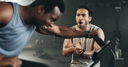 Photo for Man, cycling and personal trainer in motivation for fitness workout, exercise or training at the gym. Male person coaching or timing athlete on bicycle, machine or equipment in cardio at health club. - Royalty Free Image