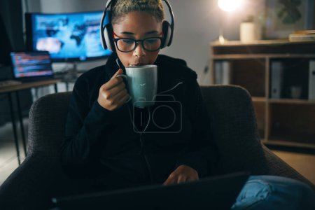 Photo for Hacker woman, coffee and night on laptop, thinking and ideas for cybersecurity, data phishing and ransomware. Programmer, dark room and sofa to drink matcha for it scam, software and coding research. - Royalty Free Image