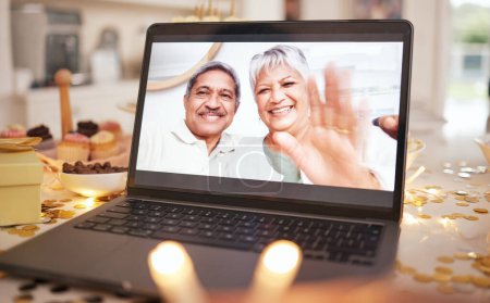 Photo for Senior couple, laptop screen and video call on table at party, event or dinner by candle, glitter or wave. Elderly man, woman and hello with smile, contact or webinar for chat for happy birthday wish. - Royalty Free Image