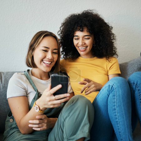 Photo for Friends, relax on sofa with smartphone and chat online with communication, funny meme and reading text message. Women with technology, mobile app and typing on social media with connectivity at home. - Royalty Free Image