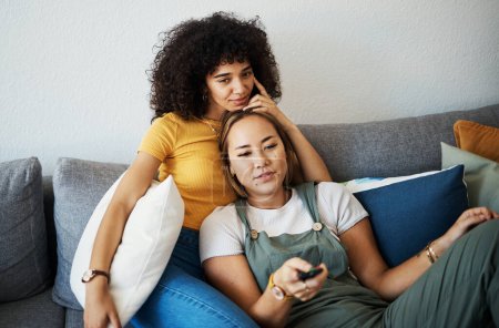 Photo for Love, relax and a gay couple watching tv on a sofa in the living room of their home together. Television, LGBT and a woman with her lesbian girlfriend for movie on a subscription streaming service. - Royalty Free Image