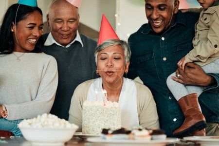Photo for Happy birthday, candles or grandma in home for a family celebration, bond or growth together. Blow, senior lady or excited grandparents with cake, support or child at a fun party or special event. - Royalty Free Image