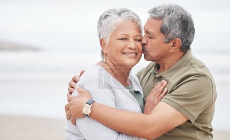 Photo for Senior couple, kiss and love at beach for holiday, vacation and tropical travel in retirement. Happy man, elderly woman and hug of affection at ocean for trust, support and loyalty to partner on date. - Royalty Free Image