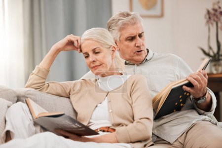 Photo for Old couple on sofa, reading book and relax together at home, retirement and wellness with love and comfort. Trust, care and support in marriage, share hobby with partner for knowledge and story. - Royalty Free Image