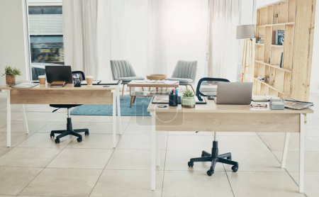 Photo for Empty office, interior and coworking space with laptop on desk in startup company. Computer, table and creative workplace room with wood furniture, chair and modern design in workspace for business. - Royalty Free Image