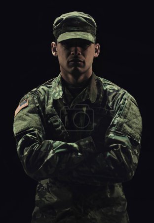 Photo for Soldier, man with arms crossed and army warrior in war, conflict and battle with uniform on black background. Hero, military and camouflage with security, protection and mission for fight in studio. - Royalty Free Image