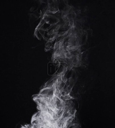 Téléchargez les photos : Encens, vapeur ou gaz dans un studio au fond sombre par un espace maquillant pour un effet magique abstrait. Brume de brouillard, de fumée ou de vapeur se déplaçant dans l'air pour créer un smog nuageux sur fond noir avec maquette - en image libre de droit