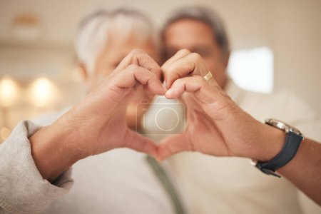 Photo for Heart hands, emoji and senior couple in home with commitment, support and marriage in retirement together. Love sign, happy man and old woman in apartment with icon for romantic gesture of loyalty - Royalty Free Image