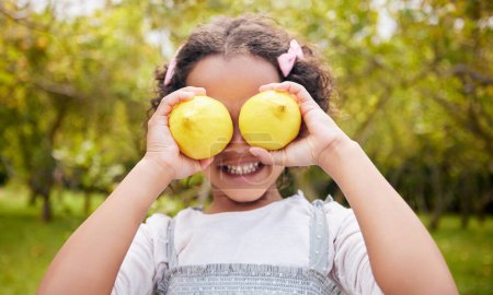 Photo for Lemon on eyes, smile and girl on farm for harvest, sustainable farming and growth in nature. Agriculture, childhood and happy kid with fruit for nutrition, healthy eating and organic food in garden. - Royalty Free Image