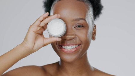 Photo for Happy black woman, face and skincare cream for beauty, cosmetics against a studio background. Portrait of African female person or model smile with lotion, moisturizer or creme for facial treatment. - Royalty Free Image