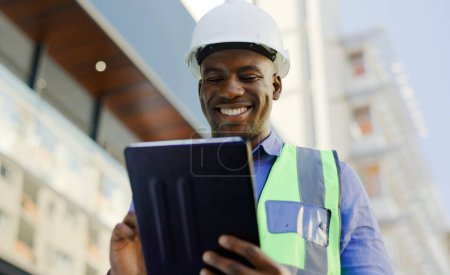 Photo for Black man in construction, tablet and architect working on floor plan, inspection and maintenance job outdoor. Check digital blueprint for architecture project, design software and quality assurance. - Royalty Free Image