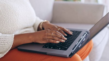 Photo for Hands, laptop and a person typing on a sofa in the living room of her home for email communication. Computer, keyboard and an adult typing a social media post or article for her online blog closeup. - Royalty Free Image