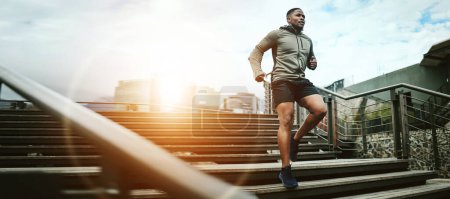 Photo for Fitness, city and black man running on steps outdoor, exercise and training healthy body in the morning at sunrise. Sports, cardio and African athlete on stairs for workout, wellness and lens flare. - Royalty Free Image