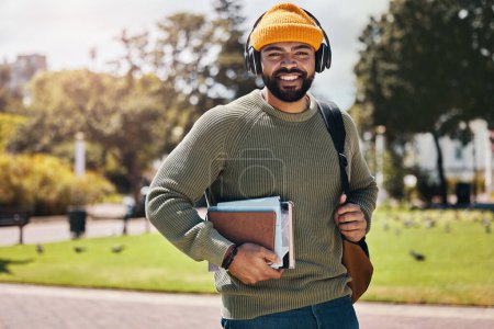 Photo for Student, headphones and backpack on campus of education, college or university podcast in park. Portrait of african man walking, travel and books with audio, electronics or listening to music outdoor. - Royalty Free Image