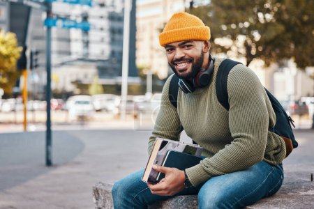 Téléchargez les photos : Portrait d'homme heureux en ville, livres universitaires et sourire le matin se détendre sur le campus pour l'éducation avec sac à dos. Apprendre, étudier et étudiant assis sur le trottoir urbain avec confiance - en image libre de droit