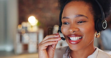 Photo for African woman, call center and night in office, talk and smile for telemarketing, voip mic or contact us. Consultant, crm and tech support agent with customer service, thinking or advice at help desk. - Royalty Free Image