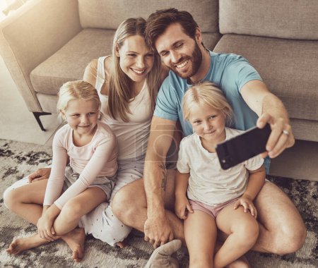 Photo for Selfie, happy family and parents with children on social media picture by living room couch together in the morning. Love, care and mother bonding with father and kids with memory online with smile. - Royalty Free Image