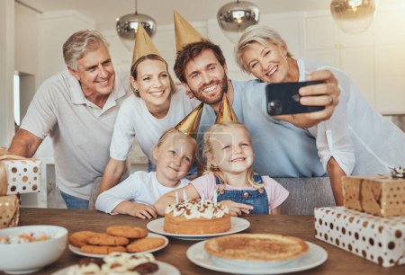 Foto de Selfie de padres, abuelos e hijos con pastel de cumpleaños para celebrar con sonrisa, amor y dulces en casa. Fotografía, familia grande y hombres, mujeres y niños juntos para una fiesta de chicas en casa - Imagen libre de derechos
