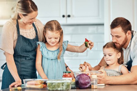 Photo for Family in kitchen, cooking together with children and teaching, learning and nutrition with parents. Mom, dad and girl kids help making healthy food in home with care, support and love at happy lunch. - Royalty Free Image
