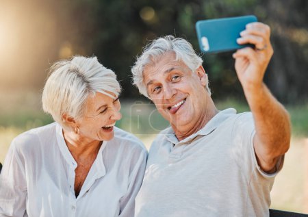 Téléchargez les photos : Couple sénior, langue et selfie dans le jardin naturel extérieur pour la mémoire d'amour, connexion et retraite emoji. Homme âgé, drôle de visage et de rire femme pour la photographie sur les médias sociaux et photo de profil. - en image libre de droit