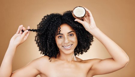 Photo for Woman, hair and coconut in portrait, beauty and product for wellness, oil or cream with cosmetics on studio background. Organic, eco friendly and haircare for growth and strong texture with fruit. - Royalty Free Image