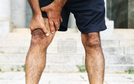 Photo for Man, hands and legs with injury, pain or ache in sports accident, emergency or outdoor exercise. Closeup of male person with sore knee, muscle or tension from workout, fitness or training mistake. - Royalty Free Image