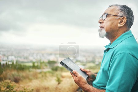 Photo for Bible, praying or senior man in nature for praise, hope or Christian religion with holy mindfulness. Prayer moment, calm pastor or mature person in worship with faith, spiritual and sky mockup. - Royalty Free Image