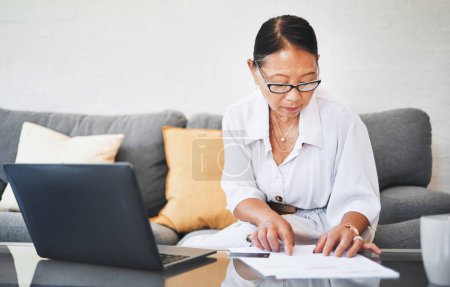 Photo for Mature woman, documents and credit card for home budget, investment and asset management on her sofa. Investor or executive on computer for work from home revenue, bank paperwork or loan application. - Royalty Free Image