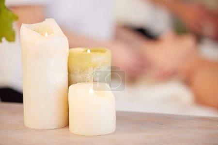 Photo for Zen, table and candles at spa during massage for relax, wellness and lighting at a hotel. Calm, peace and a flame in a room for a luxury treatment, aroma therapy or ambient experience for hospitality. - Royalty Free Image