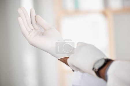 Téléchargez les photos : Docteur, enfilez-vous et portez des gants pour plus de sécurité en gros plan à l'hôpital pour le patient, l'examen ou l'assurance-maladie sur fond flou. Personne, infirmière et protection médicale, sanitaire ou thérapeutique par consultation en clinique. - en image libre de droit