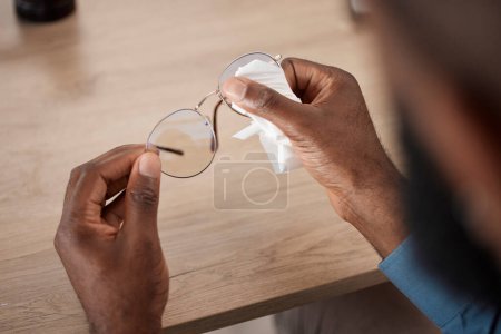 Photo for Hands, glasses and fabric for cleaning, closeup and maintenance for dust, frame and eye health in home. Person, cloth and spectacles for optometry, vision and wellness for eyesight at table in house. - Royalty Free Image