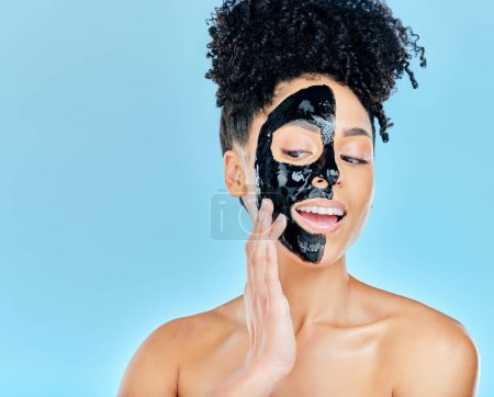 Photo for Skincare, face mask and woman in studio for charcoal facial treatment, anti aging and wellness. Beauty salon, dermatology and face of person for health, cosmetics or grooming on blue background. - Royalty Free Image