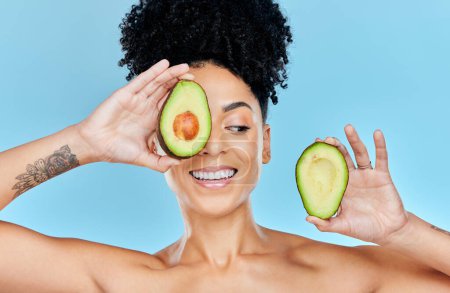 Photo for Skincare, avocado and happy woman in studio for cosmetic, wellness and treatment on blue background. Beauty, fruit and female model smile with organic, dermatology or detox for glowing skin routine. - Royalty Free Image