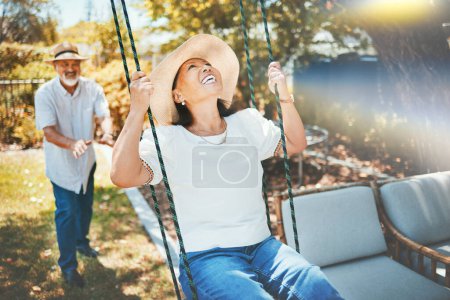 Photo for Woman, smile and fun on swing in retirement, playful and joy in summer vacation for quality time. Happy elderly people, support and love in relationship, funny and laugh for silly, goofy and holiday. - Royalty Free Image