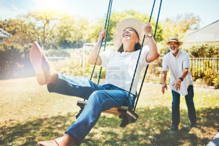 Photo for Woman, happy and fun on swing in retirement, playful and joy in summer vacation for quality time. Elderly people, support and love in relationship, funny and laugh for silly, goofy and holiday. - Royalty Free Image
