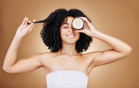 Photo for Woman, hair and coconut with shine and beauty, organic salon treatment for strong texture on studio background. Face, skin and natural cosmetic product for growth, haircare and fruit with smile. - Royalty Free Image