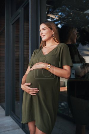 Foto de Visión, sonrisa y una mujer embarazada en un balcón de negocios en su oficina esperando ser madre. Vientre, embarazo y joven empleado feliz en el lugar de trabajo como empleado pensando en el permiso de maternidad. - Imagen libre de derechos