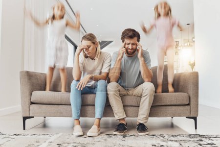 Photo for Frustrated parents, sofa and headache with children jumping in living room chaos, ADHD or crazy home. Mother and father in stress, burnout or fatigue with busy or hyper active kids in lounge at house. - Royalty Free Image