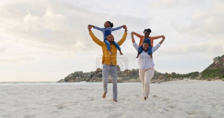 Photo for Family, children on parents shoulders at beach and travel, playful and freedom outdoor with love and bonding. Carefree, energy and holiday with people in nature, mom and dad with kids and happiness. - Royalty Free Image