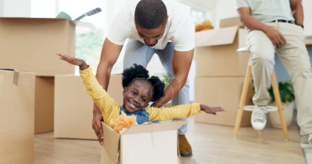Foto de Padre, jugando y niño en una caja mientras se muda casa con una familia negra juntos en una sala de estar. Hombre y un niño niña emocionados por el juego divertido en su nuevo hogar con una sonrisa, la felicidad y la energía. - Imagen libre de derechos