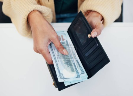 Photo for Woman, hands and wallet with money for savings, investment or payment on counter at checkout. Top view or closeup of female person with cash, bills or paper notes for finance, purchase or shopping. - Royalty Free Image