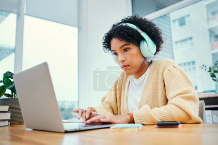 Photo for Headphones, laptop and young woman typing for research in living room listening to music, playlist or album. Technology, computer and female person from Colombia streaming song on radio for studying - Royalty Free Image