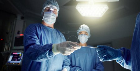 Photo for Doctors, team and equipment in surgery, healthcare and treatment for injury, support and trust. Surgeons, collaboration and hands over tool, teamwork and operation in theatre, medicare and hospital. - Royalty Free Image