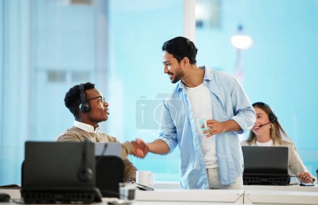 Photo for Call centre, man and handshake for teamwork in office for telecom, customer care and services. Diversity, manager and thank you for employee with headset, work and feedback on crm, web or sales. - Royalty Free Image