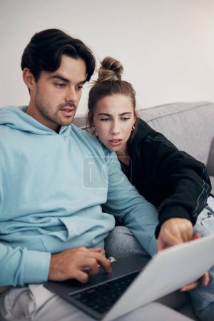 Photo for Laptop, stress and couple pointing in home living room for budget planning, taxes or debt. Computer, man and frustrated woman on sofa for finance, asset management and mortgage, loan and rent bills. - Royalty Free Image