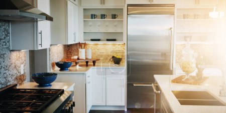 Photo for House, kitchen and clean in modern home, morning sunrise and decor in lens flare, apartment and interior design . Real estate, furniture and residential with stylish appliances, empty and spacious. - Royalty Free Image
