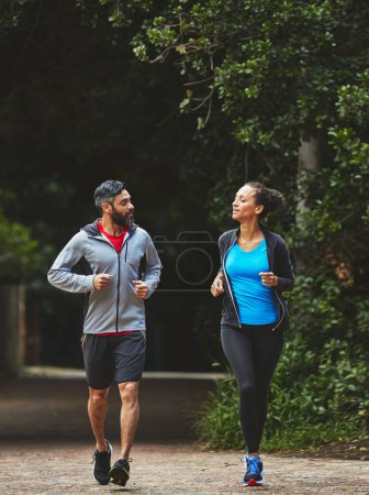 Photo for Couple, running in park for exercise and health outdoor, support and training for marathon with cardio. Runner, athlete and sport with people in nature, challenge and fitness with workout for race. - Royalty Free Image