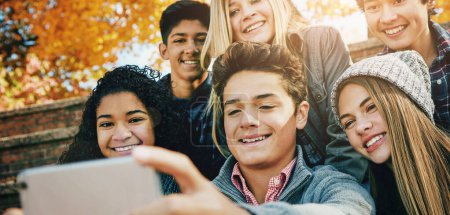 Photo for Smile, friends and a selfie in nature for bonding, fun and video call in autumn. Happy, together and diversity of kids taking a photo on technology in a park for social media or live streaming. - Royalty Free Image