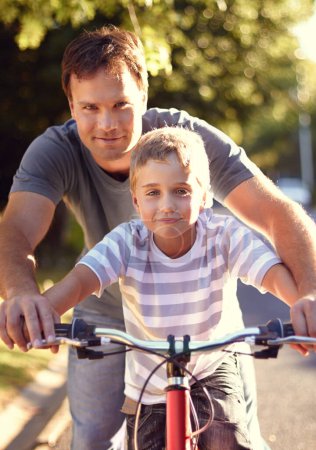 Photo for Bicycle, ride and father help child with bike and learning on the road and parent support kid in vacation or holiday. Smile, development and dad together with son and teaching outdoor skills. - Royalty Free Image